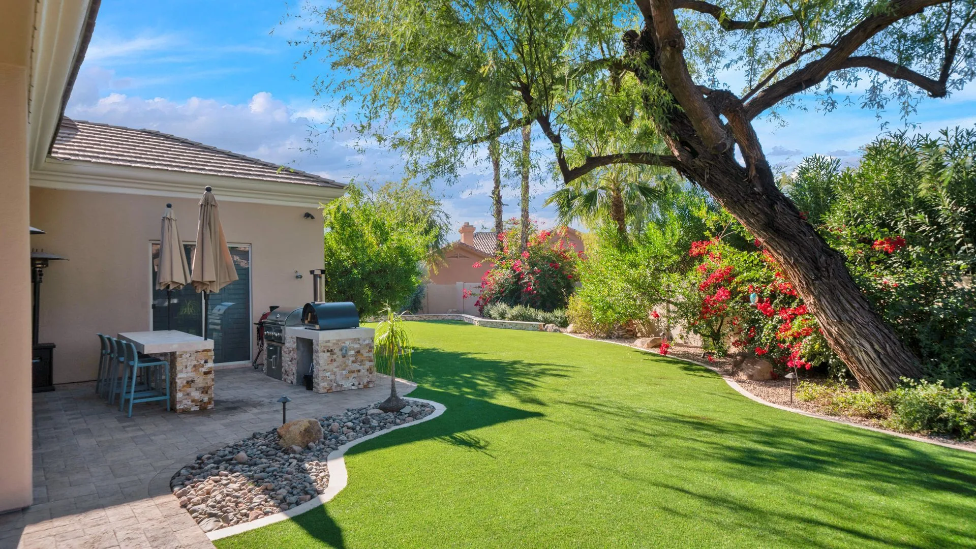 Lush, well-irrigated Phoenix backyard with green turf and healthy planting