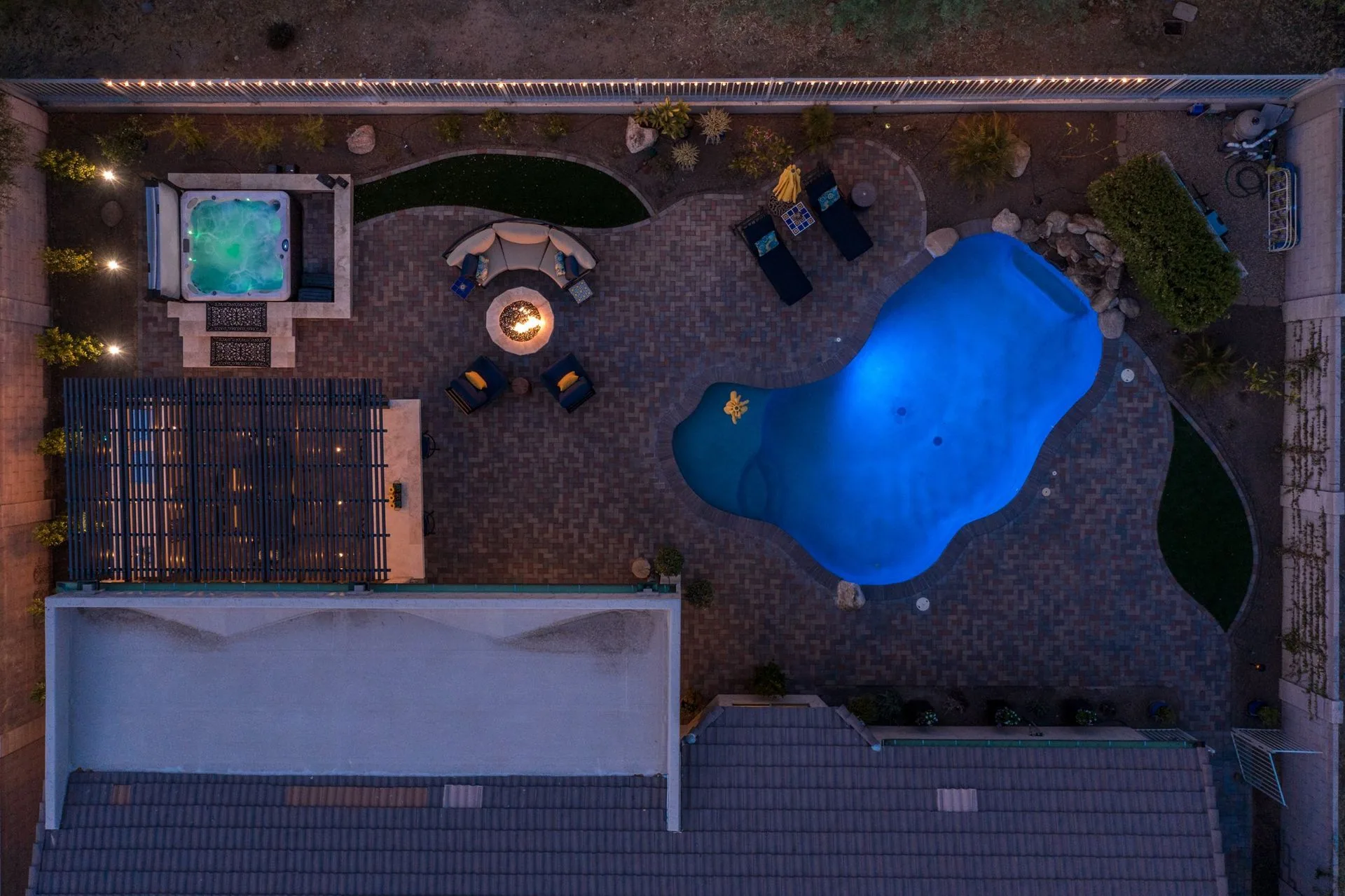 Aerial of a designed backyard with pool, spa, and patio layout