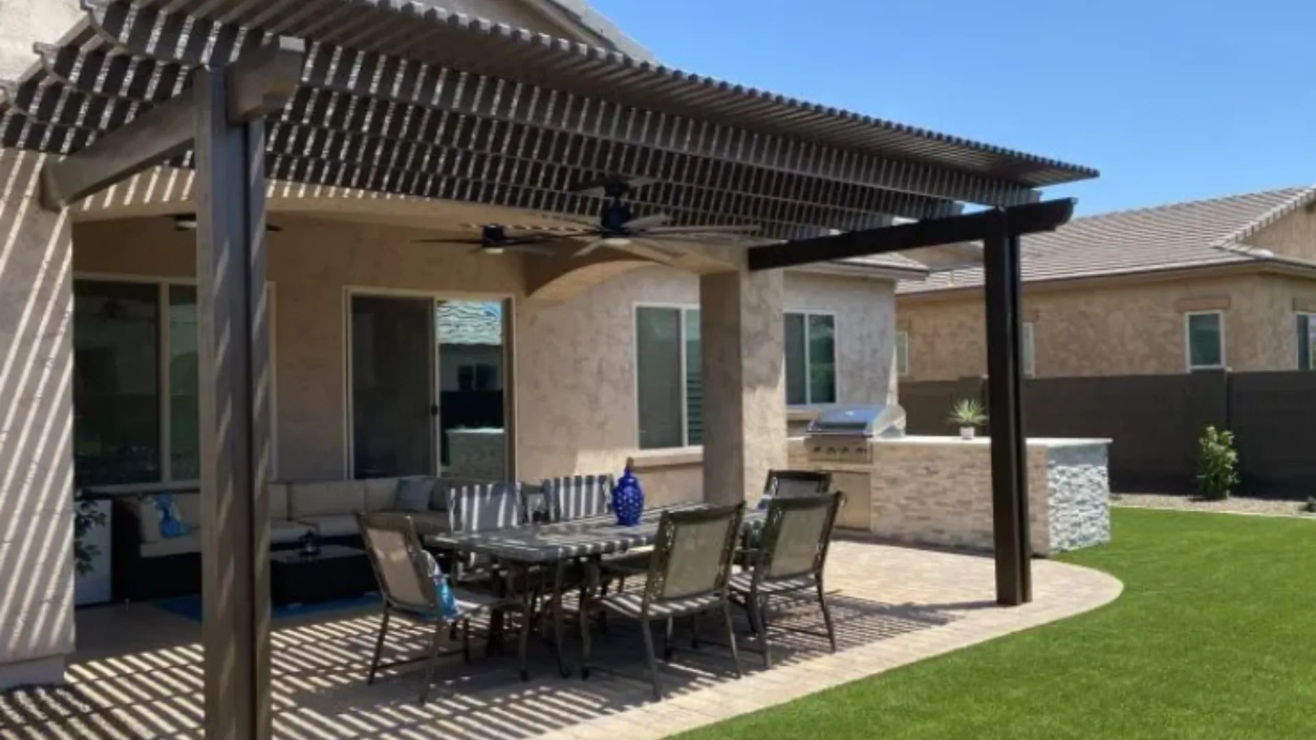 Attached pergola with a ceiling fan over a paver dining patio