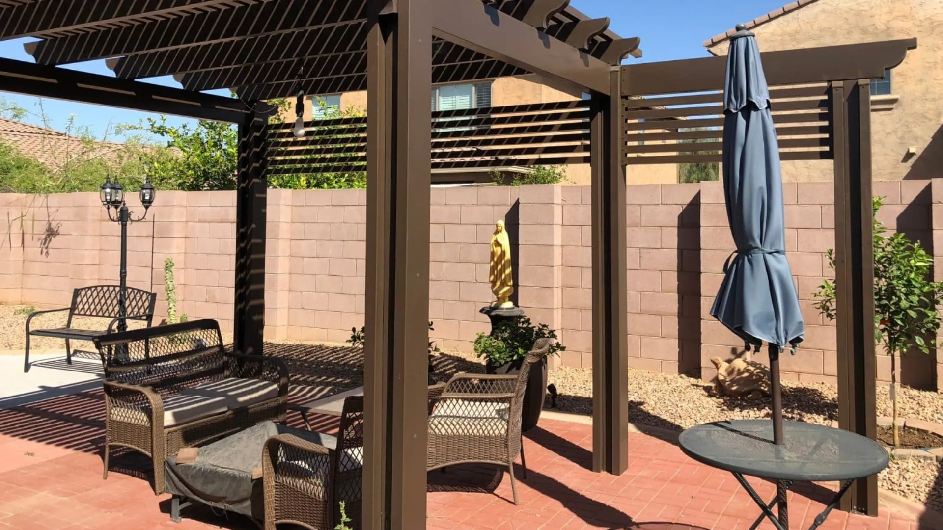 Powder-coated metal pergola with a slatted top over a patio