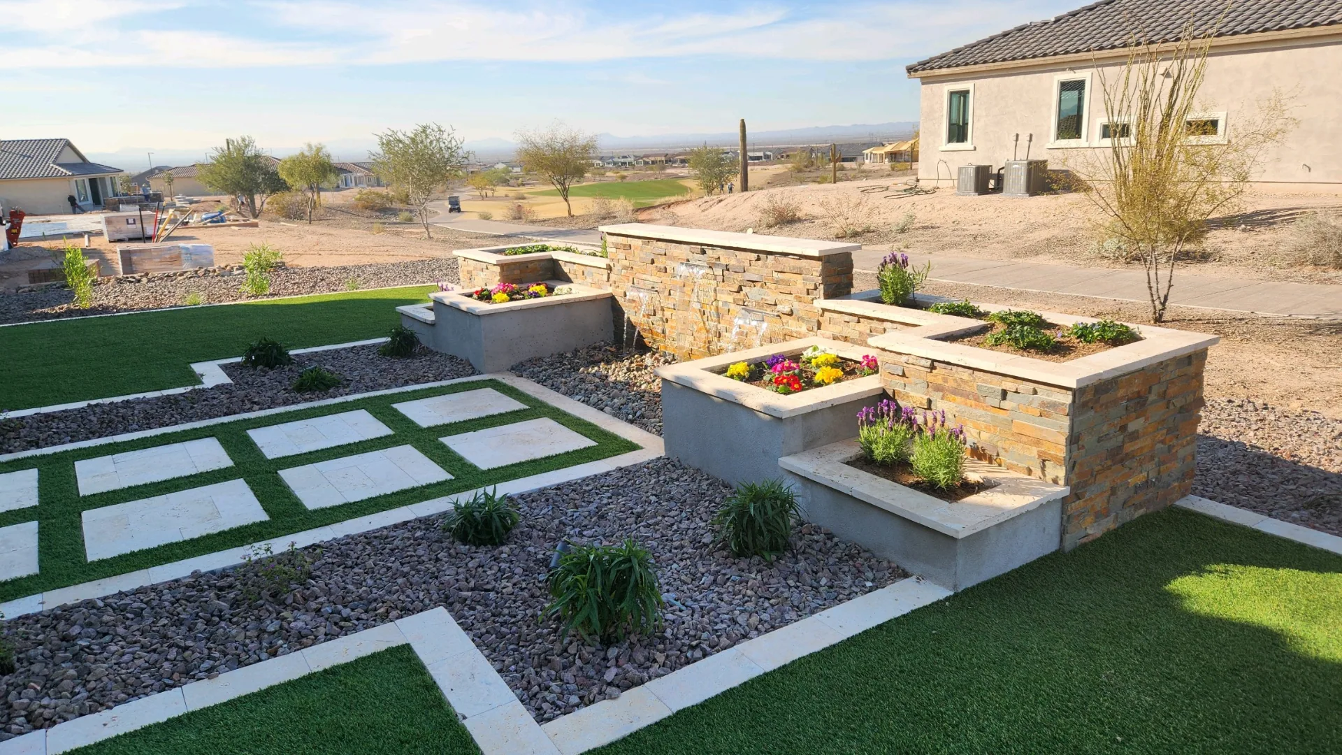 Stone-veneer water and planter feature in a desert backyard